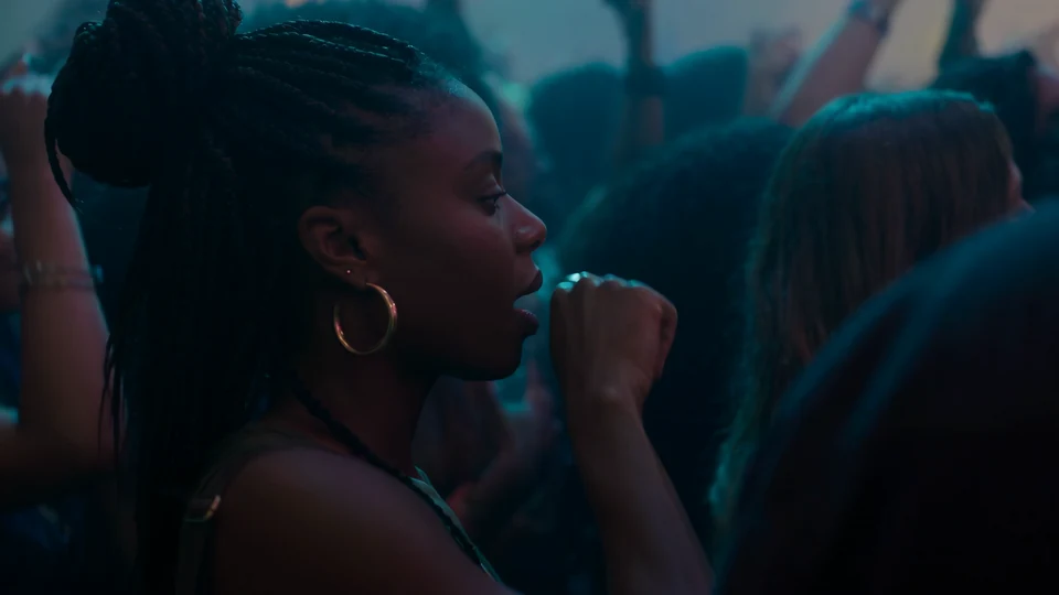 The selected teaser scene: a woman speaking to Interface in a nightclub