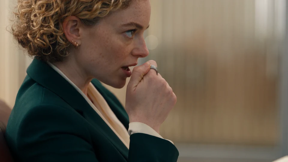 The selected teaser scene: a woman whispering to Interface in a waiting room