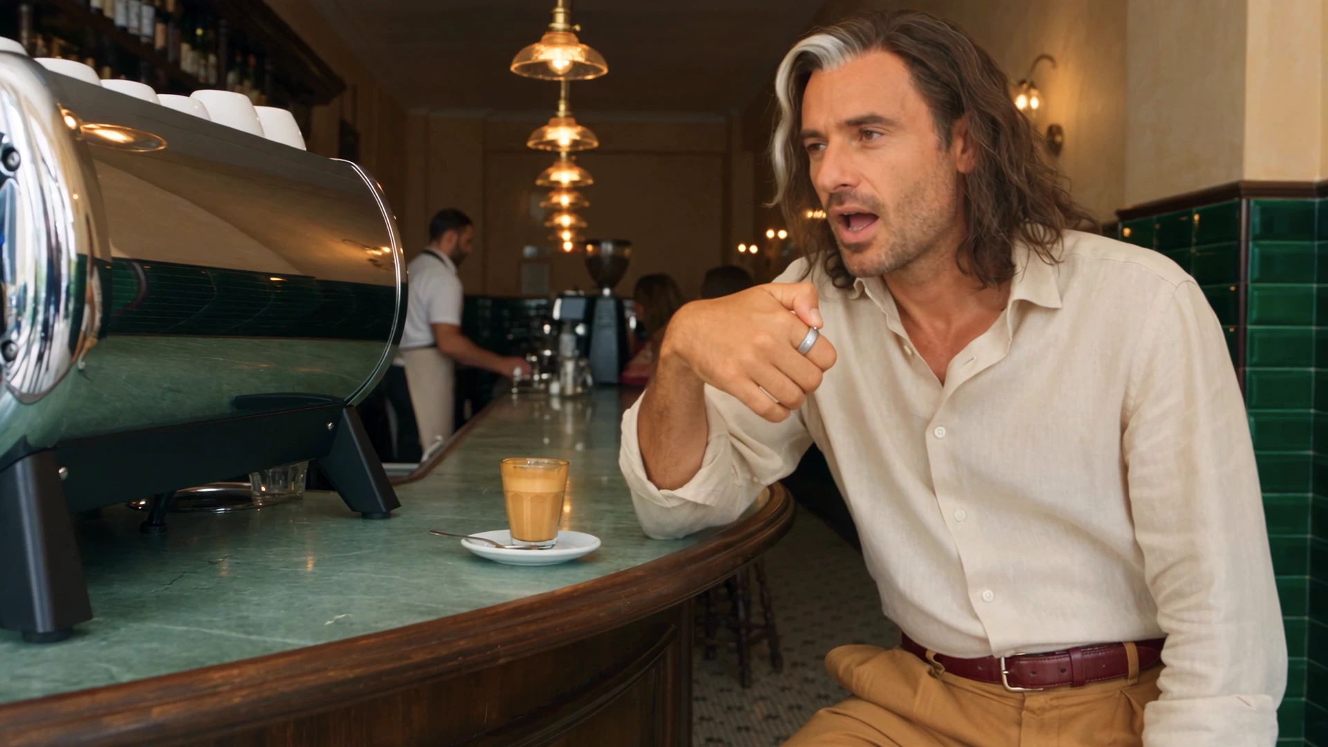 A man makes a request through Interface at a café, with the ring on his index finger and his phone out of sight. A frame from the latest teaser.